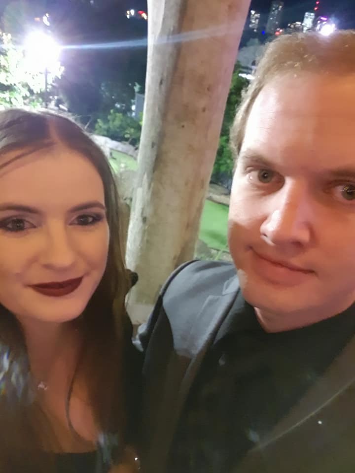 Two people taking a selfie outdoors at night.